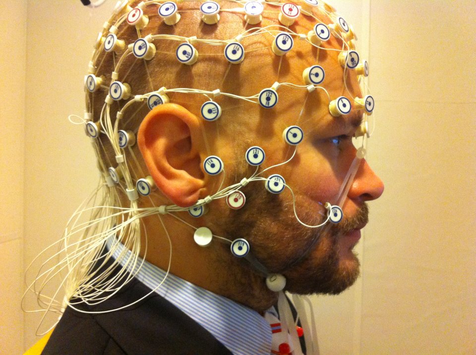 Participant wearing an EEG electrode cap at a phonetics laboratory