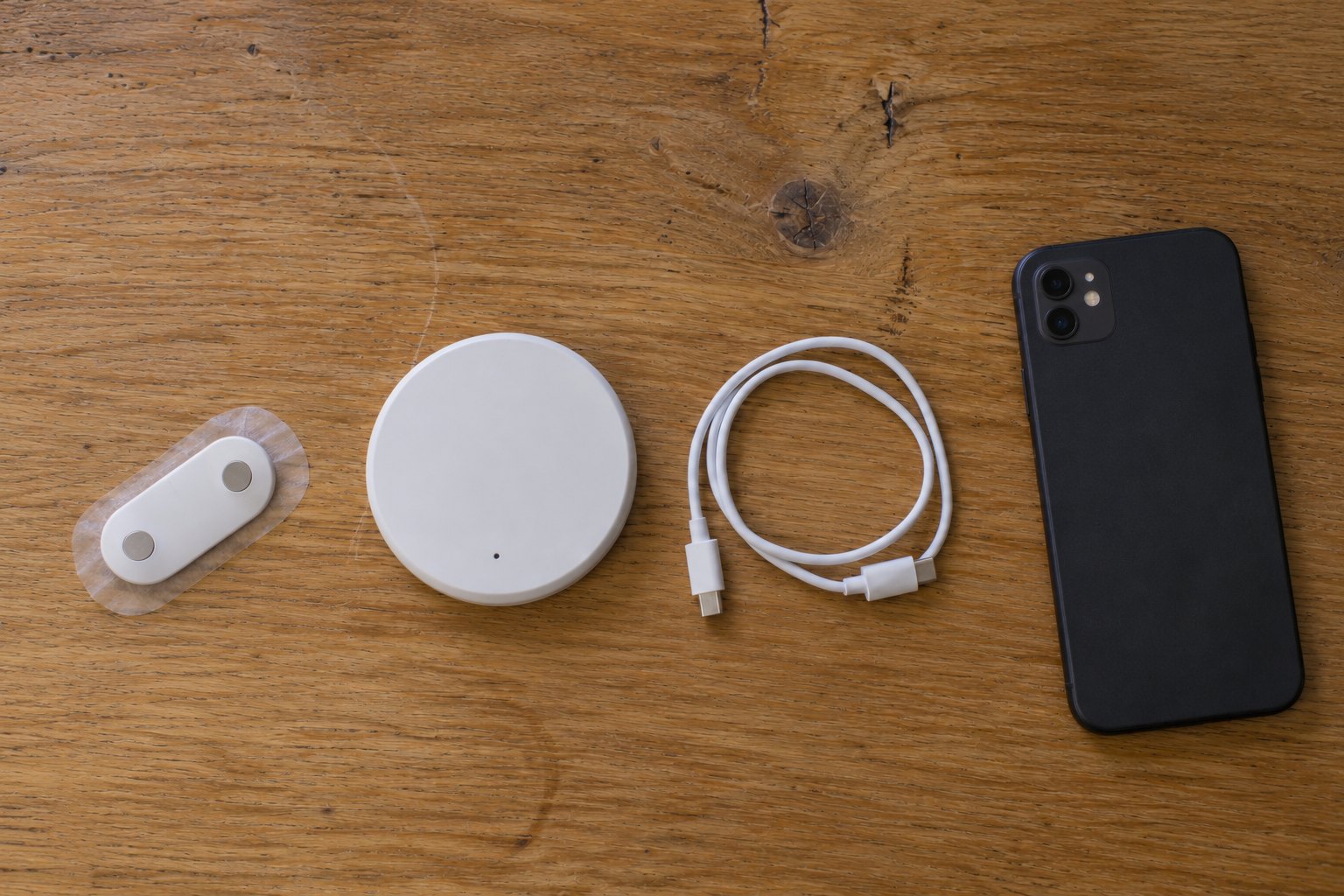 Concept render: a patch, a hub and a phone laid out together on a table.